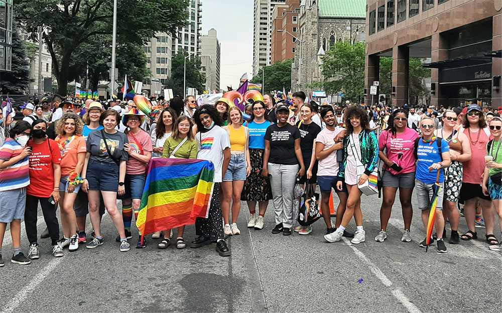 Group of people behind a pride flag