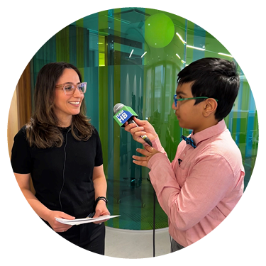 A child is holding a microphone to interview an adult