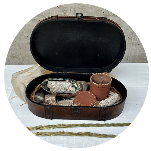 Items that are often used in smudging ceremonies are pictured above including an abalone shell, cedar bundles, a birch bark basket to hold tobacco and a sweetgrass.