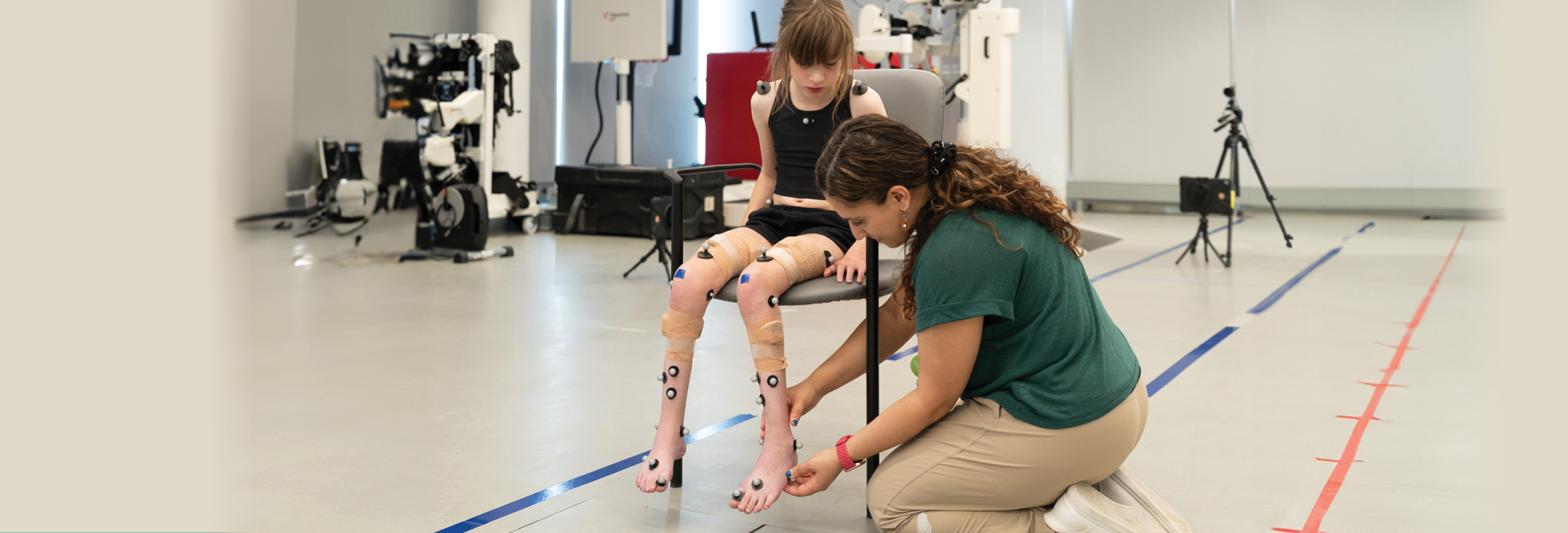 An adult putting on some sensors on a kid's foot