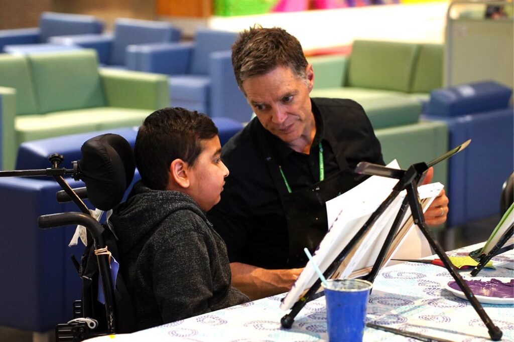 An adult sharing ideas of drawing a picture for a kid